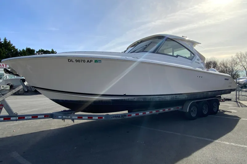 Slide: The Image of 2024 Pursuit DC 326 Dual Console boat on a trailer in a parking lot. - 6