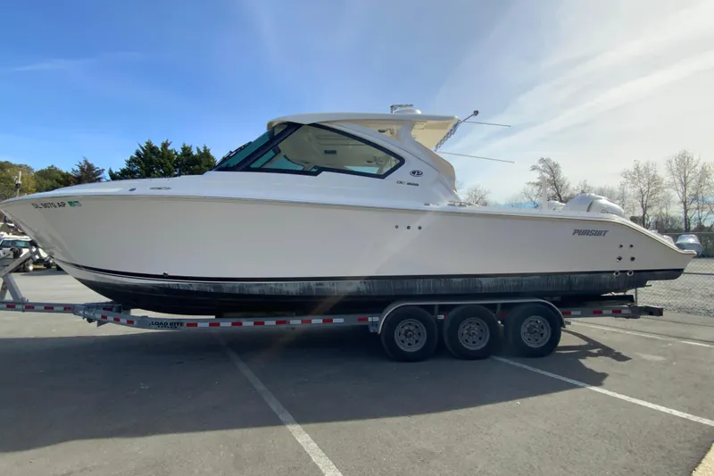Slide: The Image of 2024 Pursuit DC 326 Dual Console boat on a trailer, side view. - 7