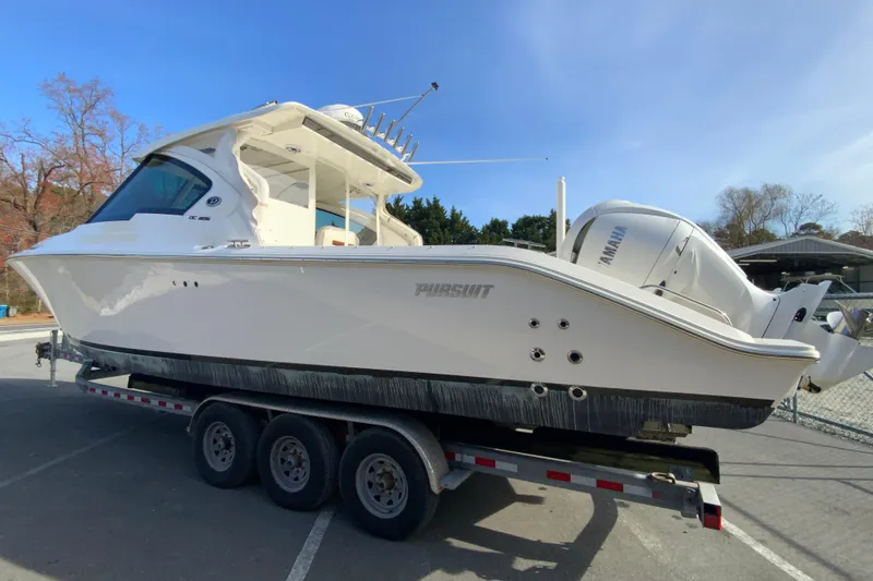 Slide: The Image of 2024 Pursuit DC 326 Dual Console boat on trailer, featuring twin Yamaha outboard engines. - 8