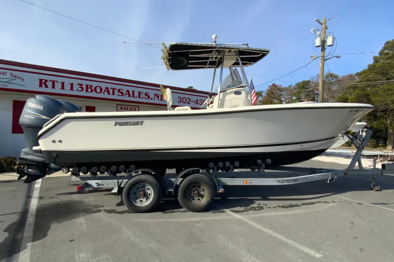 The Image of 2005 Pursuit 2570 Center Console boat on trailer at dealership. - 1