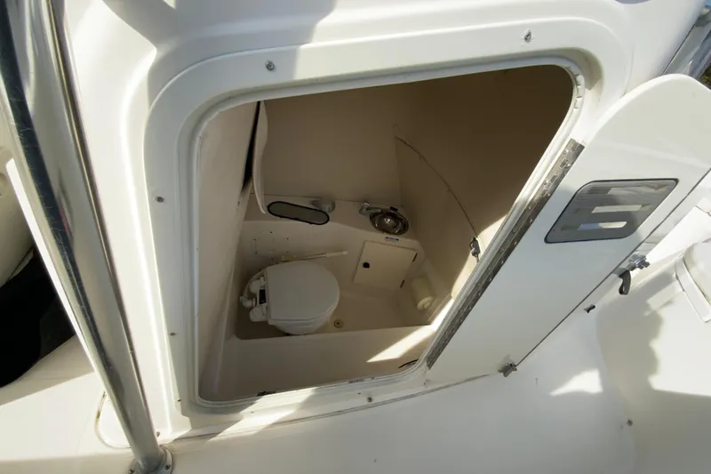 Slide: The Image of 2005 Pursuit 2570 Center Console boat interior with compact marine toilet. - 23