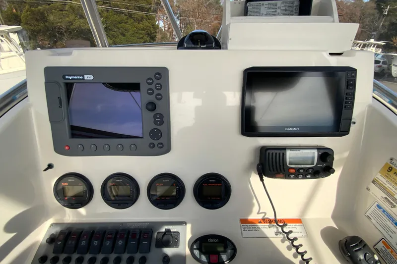 Slide: The Image of 2005 Pursuit 2570 Center Console dashboard with Raymarine and Garmin displays. - 8