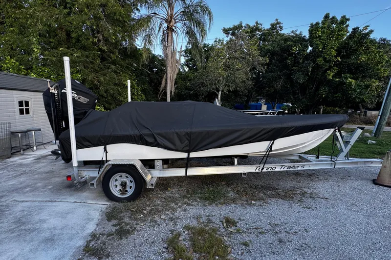 Slide: The Image of Covered Vtech 18 boat on trailer, surrounded by trees, 2024 model. - 9