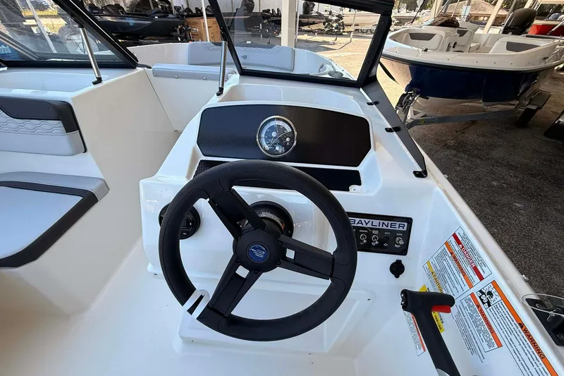 Slide: The Image of 2026 Bayliner M17 boat cockpit with steering wheel and dashboard controls. - 2