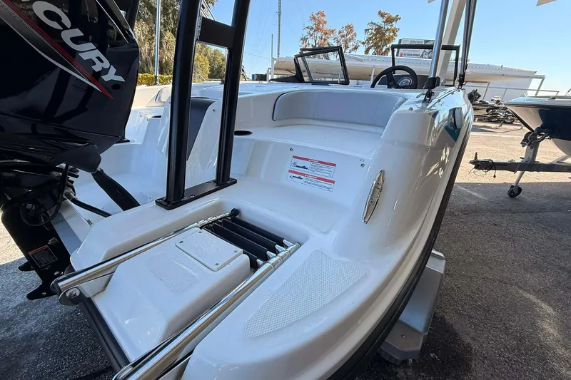 Slide: The Image of 2026 Bayliner M17 boat with outboard motor and swim platform, docked outdoors. - 4