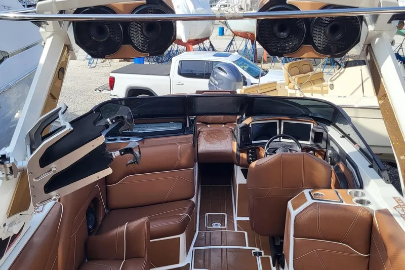 Slide: The Image of 2021 Centurion Ri265 boat interior with brown leather seating and advanced dashboard controls. - 11