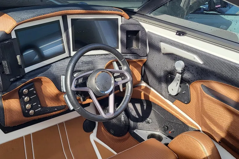 Slide: The Image of 2021 Centurion Ri265 boat dashboard with dual screens and modern steering wheel. - 13