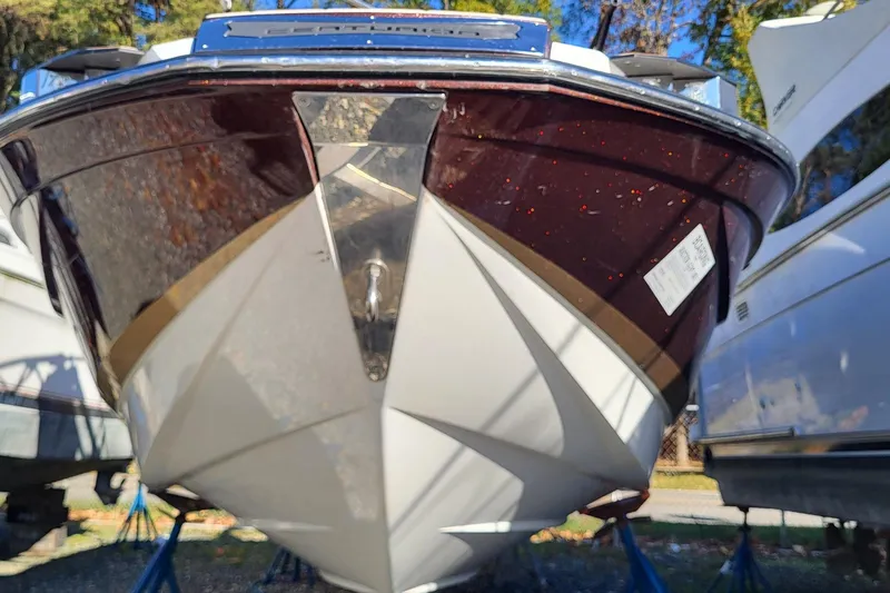 Slide: The Image of 2021 Centurion Ri265 boat on stands, viewed from the front, outdoors. - 19