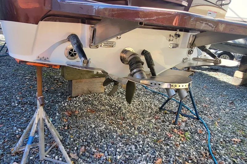 Slide: The Image of 2021 Centurion Ri265 boat stern with propeller and exhaust system on gravel. - 4