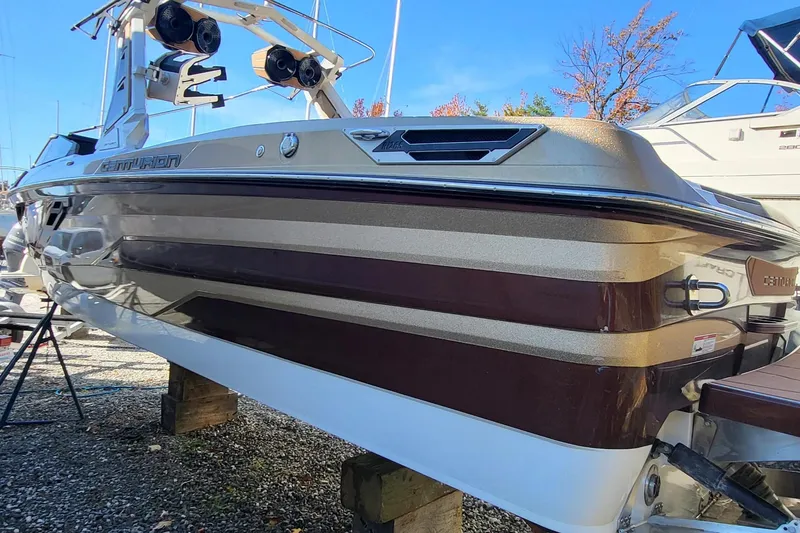 Slide: The Image of 2021 Centurion Ri265 boat with sleek design, parked outdoors on a sunny day. - 5