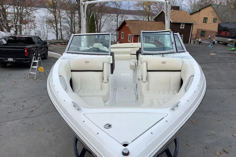 Slide: The Image of 2014 Cobalt R5 boat with white interior, parked near a lake and houses. - 10