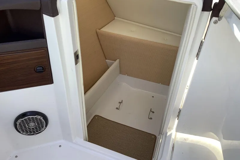 Slide: The Image of 2014 Cobalt R5 boat interior storage compartment with beige upholstery and speaker. - 16