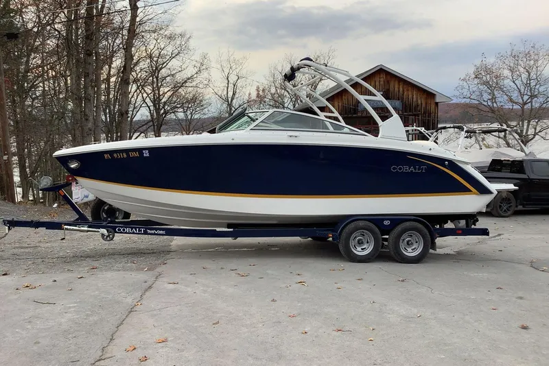 Slide: The Image of 2014 Cobalt R5 boat on trailer, parked outdoors with trees and building in background. - 4