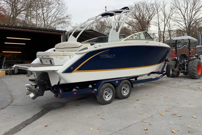 Slide: The Image of 2014 Cobalt R5 boat on trailer, parked outdoors near a garage. - 6
