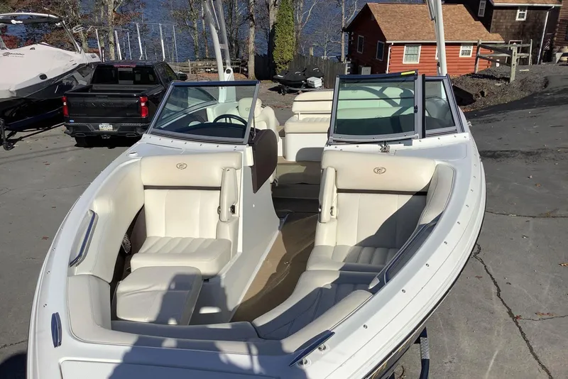 Slide: The Image of 2014 Cobalt R5 boat with white interior, parked near a lake and cabin. - 9