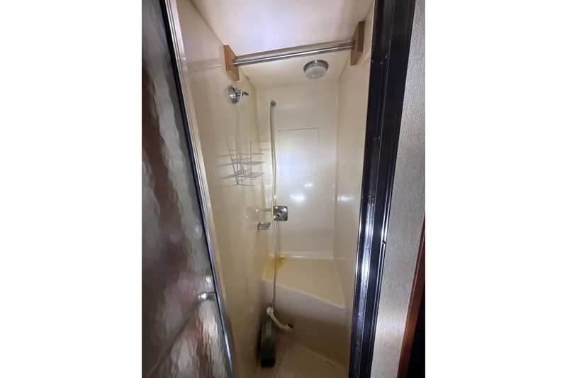 Slide: The Image of Shower area in 1984 Viking 44 Motor Yacht with glass door and built-in shelving. - 101
