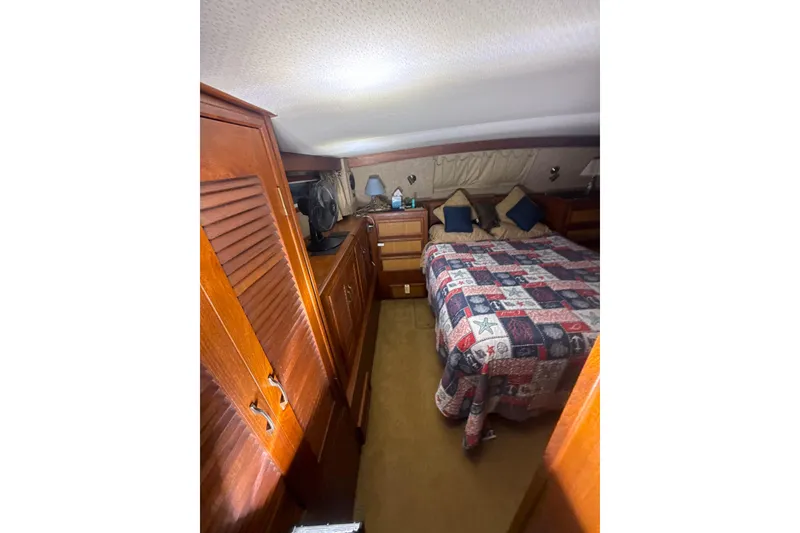 Slide: The Image of 1984 Viking 44 Motor Yacht cabin with cozy bed and wooden cabinetry. - 102