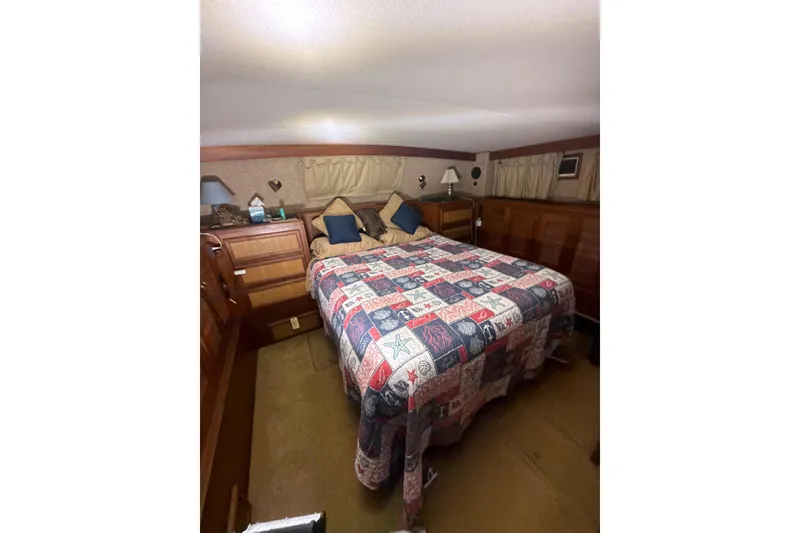 Slide: The Image of Cozy bedroom interior of 1984 Viking 44 Motor Yacht with patterned quilt and wooden cabinetry. - 103