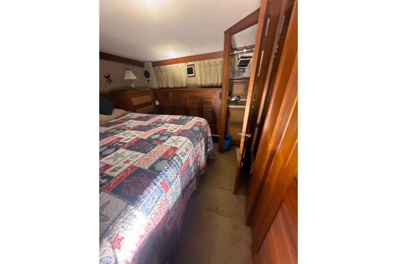Slide: The Image of Cozy bedroom interior of 1984 Viking 44 Motor Yacht with quilted bedspread. - 104