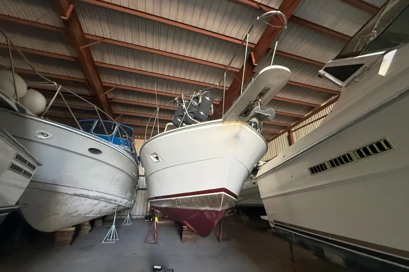 Slide: The Image of 1984 Viking 44 Motor Yacht stored in a boat shed, surrounded by other vessels. - 11