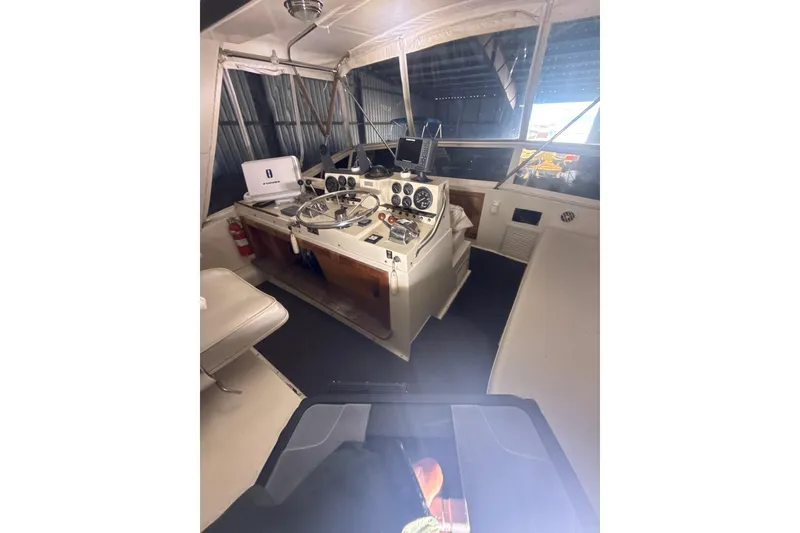 Slide: The Image of 1984 Viking 44 Motor Yacht helm with steering wheel, gauges, and navigation equipment. - 113