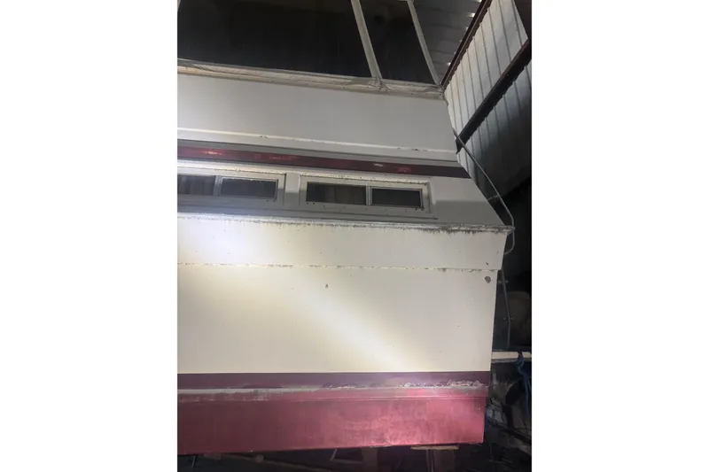 Slide: The Image of 1984 Viking 44 Motor Yacht in storage, rear view with windows and maroon trim. - 125
