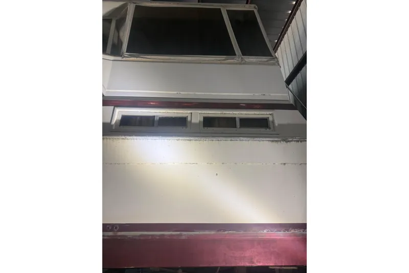 Slide: The Image of 1984 Viking 44 Motor Yacht, rear view in storage, showcasing windows and structure. - 126