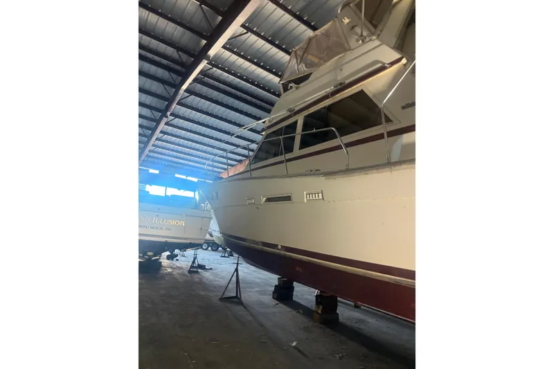 Slide: The Image of 1984 Viking 44 Motor Yacht in storage, side view under a metal roof. - 128