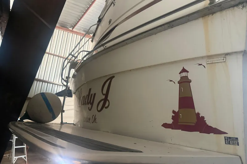 Slide: The Image of 1984 Viking 44 Motor Yacht in storage, featuring lighthouse graphic and "Lady J" text. - 130