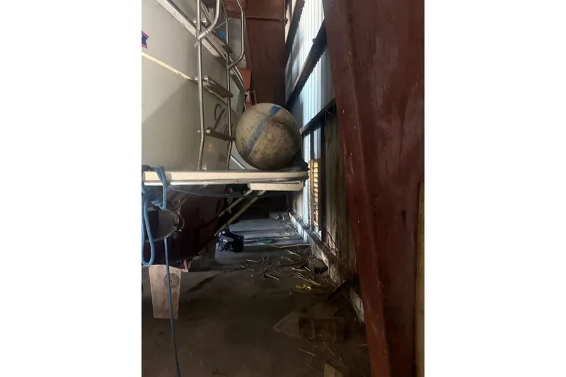 Slide: The Image of 1984 Viking 44 Motor Yacht in storage, showing stern with fender and ladder. - 134