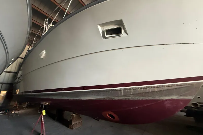 Slide: The Image of 1984 Viking 44 Motor Yacht in storage, showcasing hull and port window. - 18