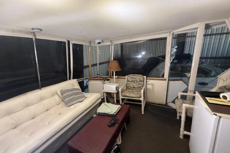 Slide: The Image of 1984 Viking 44 Motor Yacht interior with sofa, chairs, and table in enclosed cabin. - 23