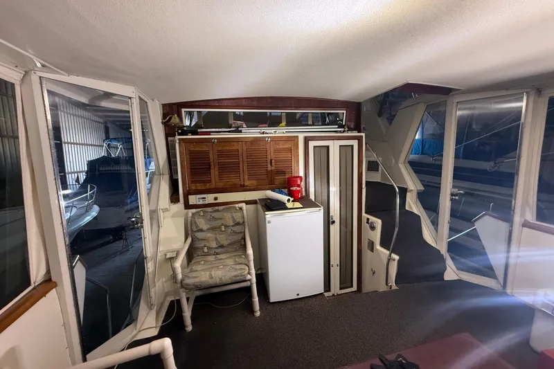 Slide: The Image of 1984 Viking 44 Motor Yacht interior with seating, storage, and windows. - 26