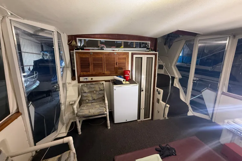 Slide: The Image of 1984 Viking 44 Motor Yacht interior with seating, mini fridge, and storage cabinets. - 27