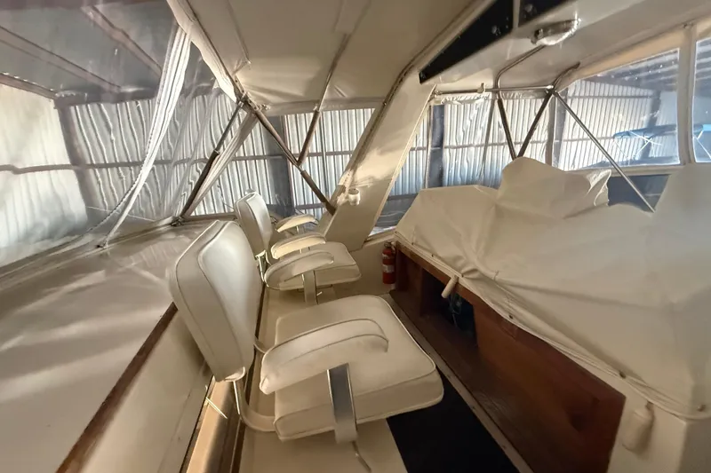 Slide: The Image of 1984 Viking 44 Motor Yacht interior with white seating and covered controls. - 29