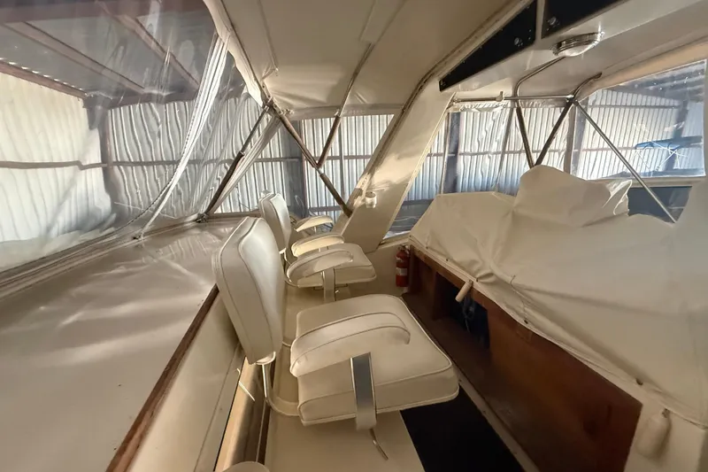 Slide: The Image of 1984 Viking 44 Motor Yacht interior with white seating and covered controls. - 30