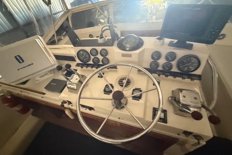 Slide: The Image of 1984 Viking 44 Motor Yacht helm with steering wheel, gauges, and navigation equipment. - 33
