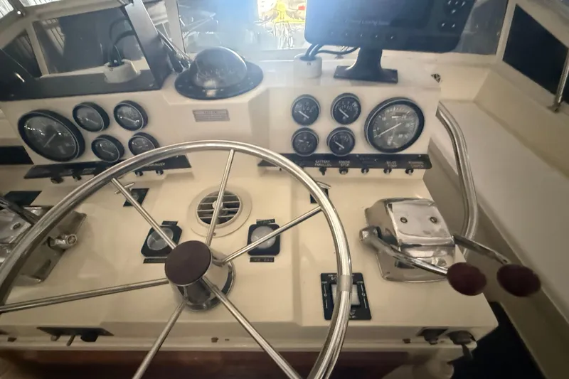 Slide: The Image of Control panel of a 1984 Viking 44 Motor Yacht with steering wheel and gauges. - 34