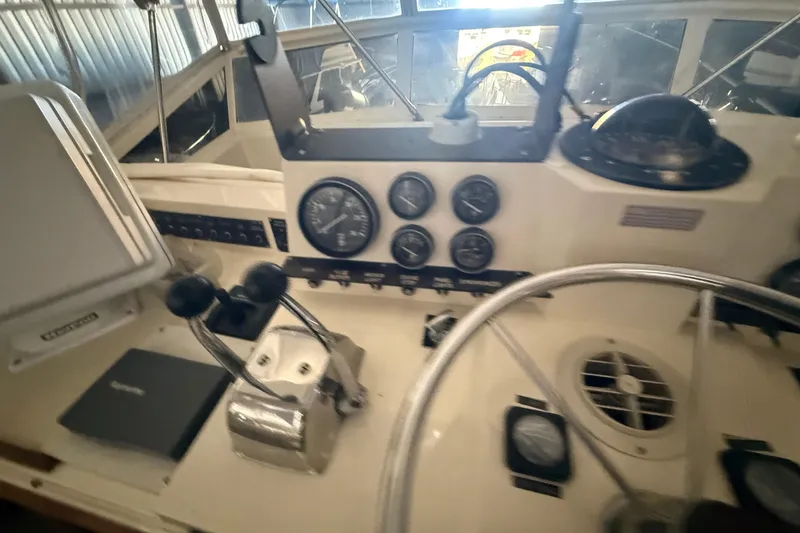 Slide: The Image of 1984 Viking 44 Motor Yacht helm with gauges, steering wheel, and controls. - 36
