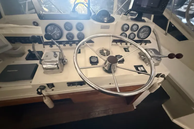 Slide: The Image of 1984 Viking 44 Motor Yacht helm with steering wheel and control panel. - 38