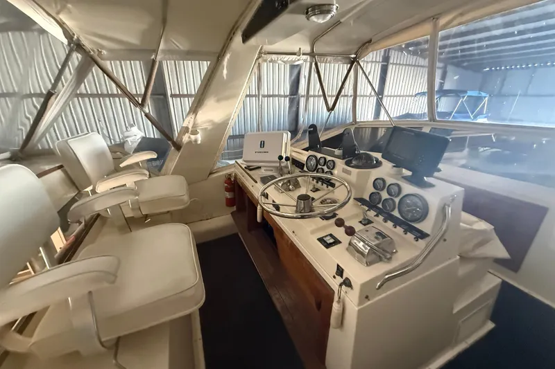 Slide: The Image of 1984 Viking 44 Motor Yacht helm with steering wheel, gauges, and navigation equipment. - 44