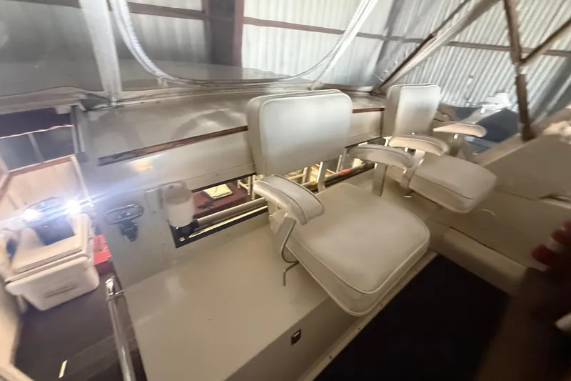 Slide: The Image of 1984 Viking 44 Motor Yacht interior with white seating and helm area. - 47