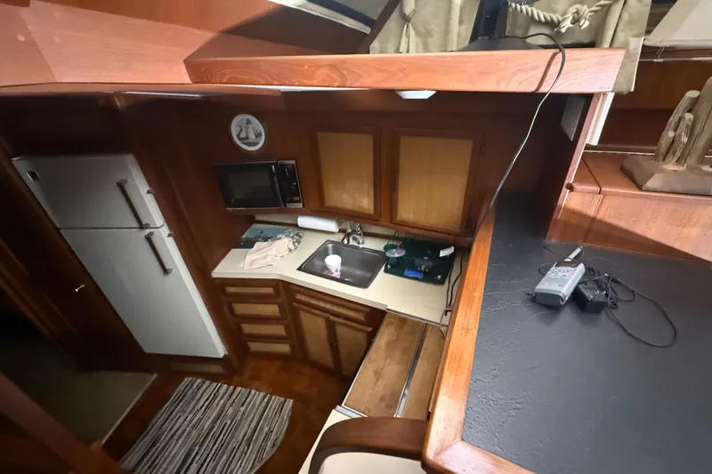 Slide: The Image of 1984 Viking 44 Motor Yacht kitchen with wood cabinetry, sink, microwave, and refrigerator. - 53