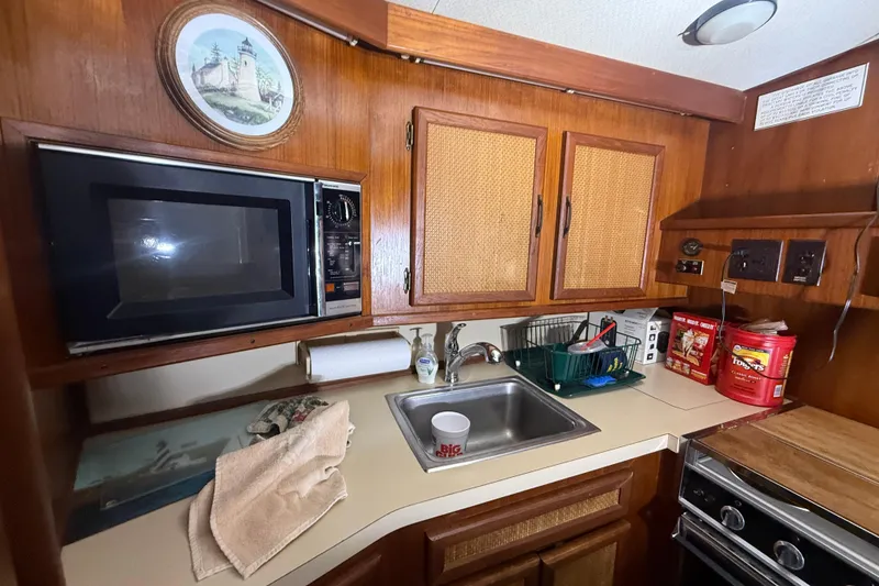 Slide: The Image of 1984 Viking 44 Motor Yacht kitchen with microwave, sink, and wooden cabinetry. - 56