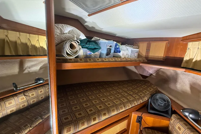 Slide: The Image of 1984 Viking 44 Motor Yacht cabin with storage, fan, and patterned bedding. - 63