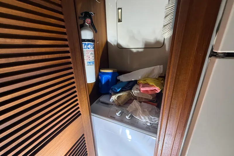 Slide: The Image of Laundry area on 1984 Viking 44 Motor Yacht with fire extinguisher and wooden paneling. - 65