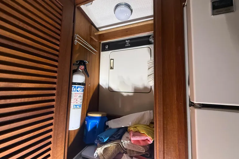 Slide: The Image of Laundry area in 1984 Viking 44 Motor Yacht with dryer, fire extinguisher, and storage. - 67