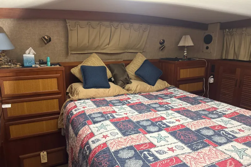Slide: The Image of Cozy bedroom in 1984 Viking 44 Motor Yacht with nautical-themed bedding and wooden cabinetry. - 79