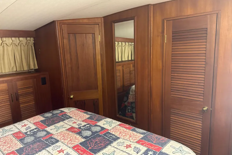 Slide: The Image of Interior of 1984 Viking 44 Motor Yacht with wood paneling and nautical-themed bedding. - 82