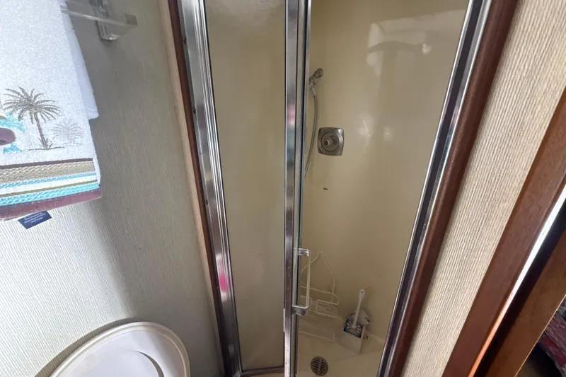 Slide: The Image of Shower area inside 1984 Viking 44 Motor Yacht with tropical-themed towel. - 86
